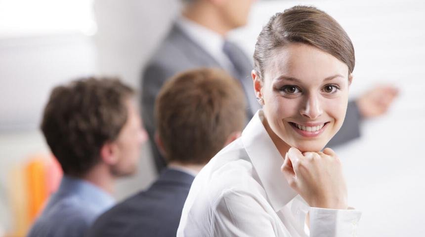 Meeting Young businesswoman smiling in a meeting with her colleagues in background